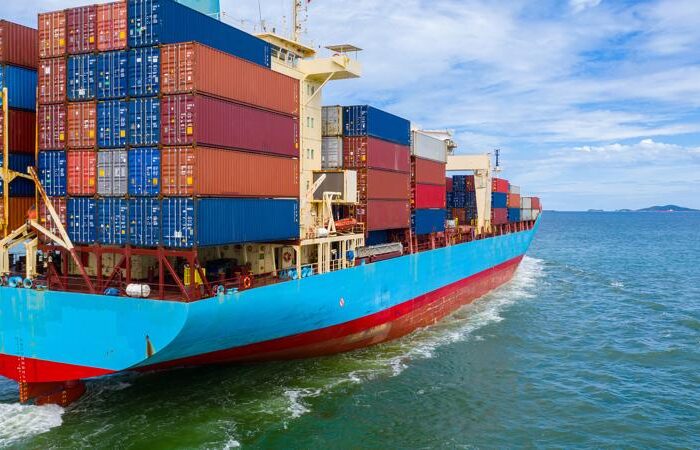 Container ship loading and unloading in deep sea port, Aerial top view of business logistic import and export freight transportation by container ship in open sea.